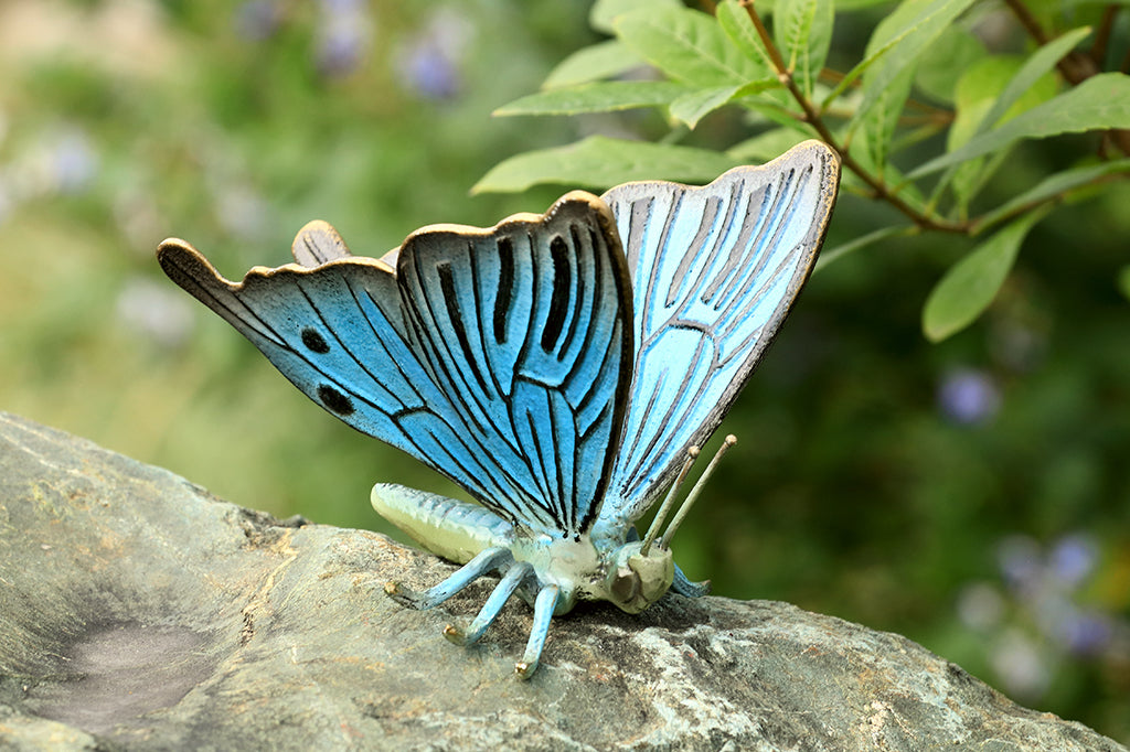 blue butterfly garden sculpture set in garden