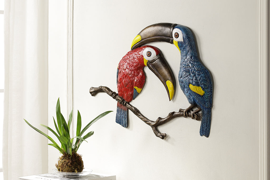 Metal Toucan pair one red and one blue wall plaque staged on wall