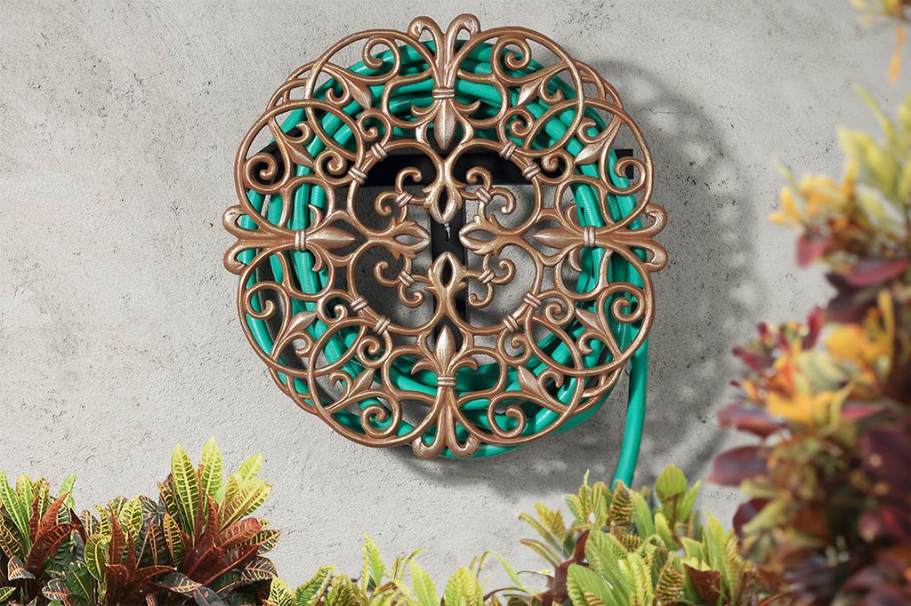 Metal rose gold tinted hose holder staged on outdoor wall