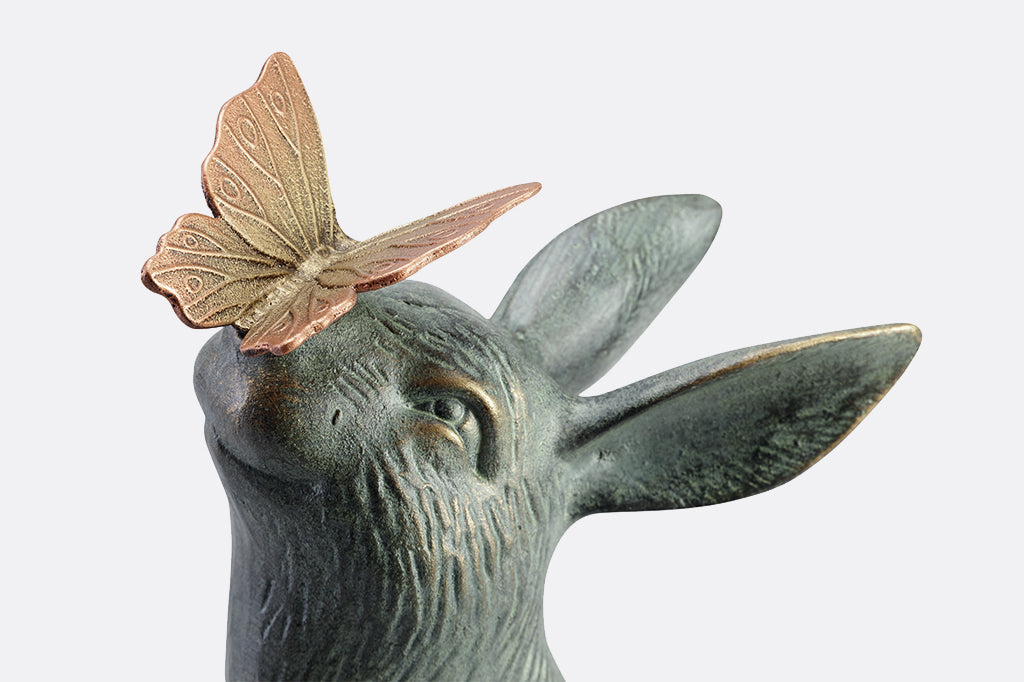 Close up of cast metal sculpture with bronze butterfly on nose of bunny