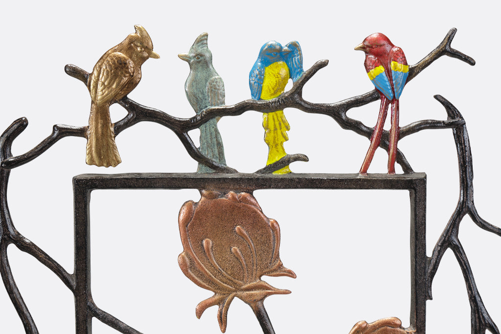Metal garden trellis featuring quartet of birds, blue and red parrot, and flycatcher and cardinal 