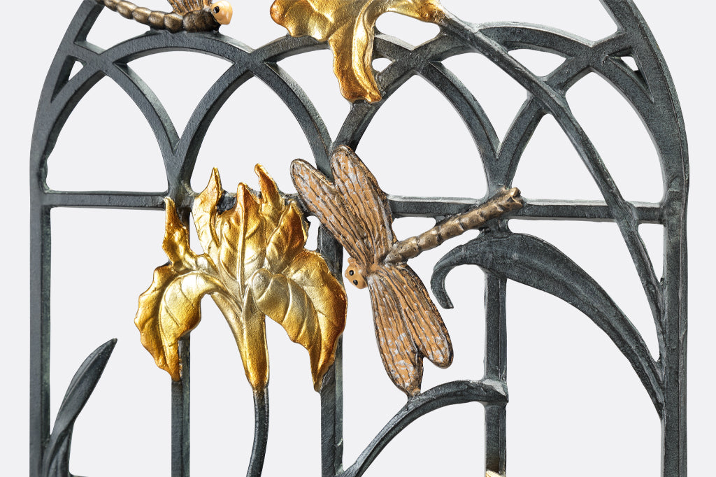 detailed view of garden trellis, with white and gold iris flower details and golden dragonflies