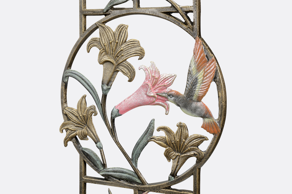 detailed view of circle on trellis with bronze and pink lilies and hummingbird imagery