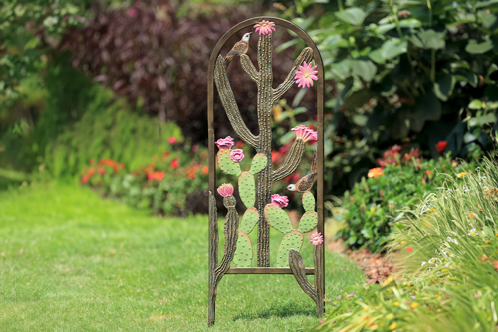 garden trellis shown in flower garden; it features two cacti with pink blooms and cast metal birds
