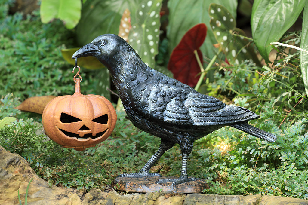 black raven holding jack o lantern cast metal sculpture