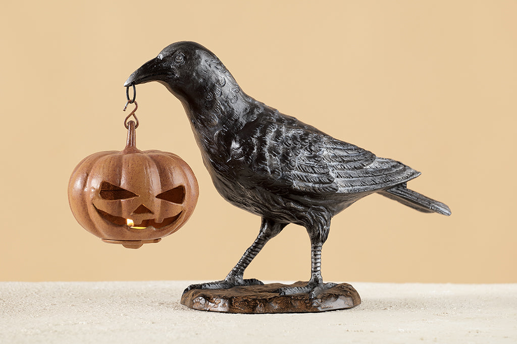 black raven holding jack o lantern cast metal sculpture