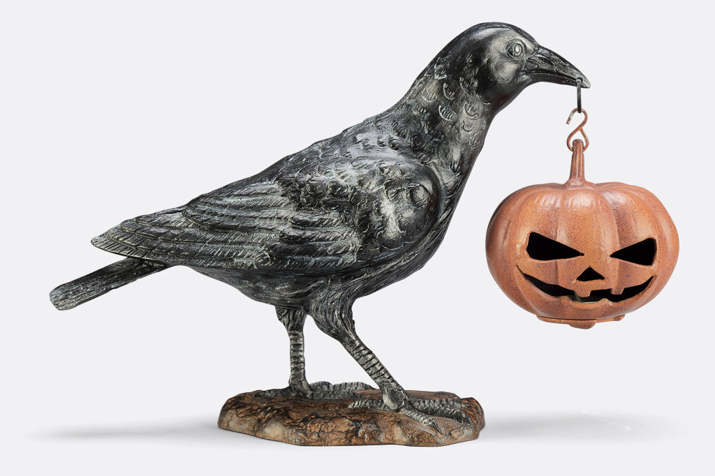 black raven holding jack o lantern cast metal sculpture
