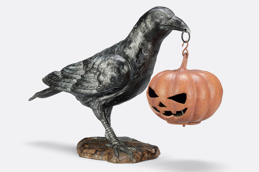 black raven holding jack o lantern cast metal sculpture
