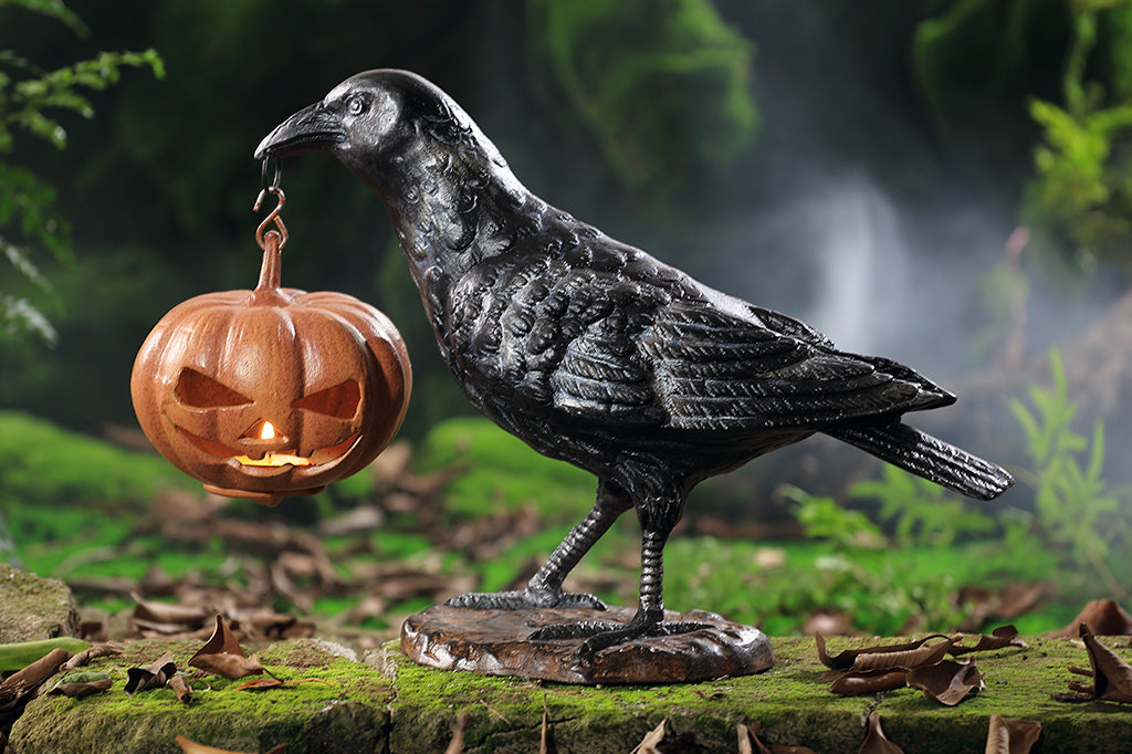 black raven holding jack o lantern cast metal sculpture