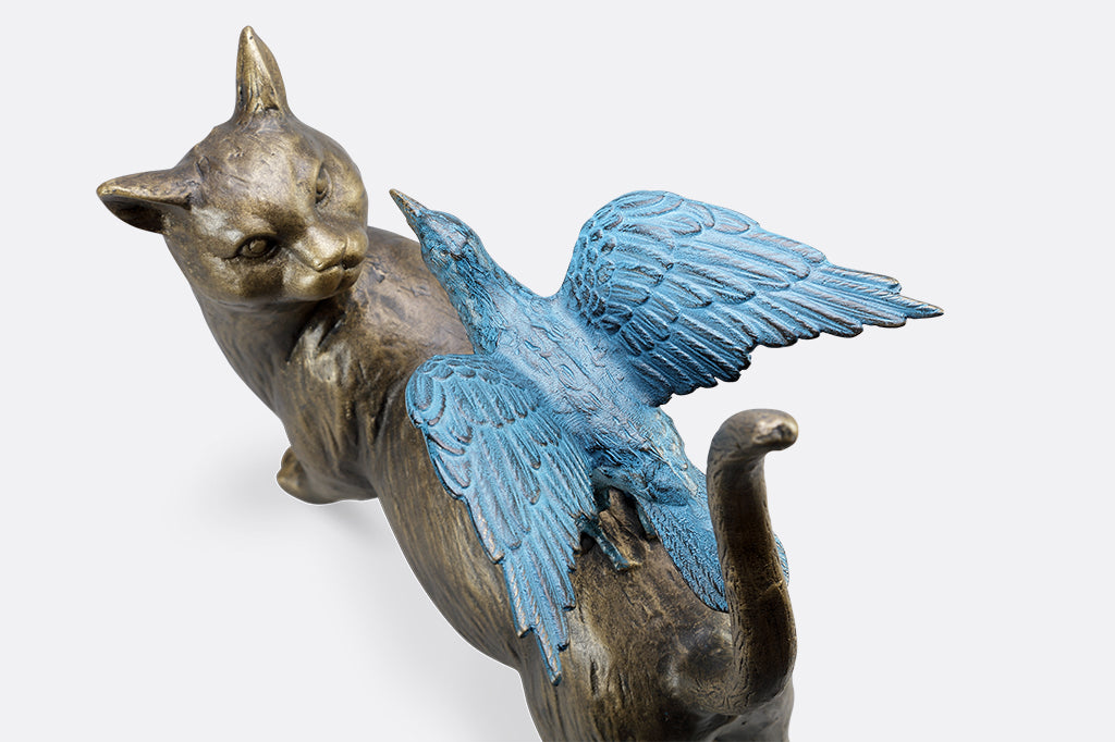 close-up detail of blue crow on cat's back garden sculpture