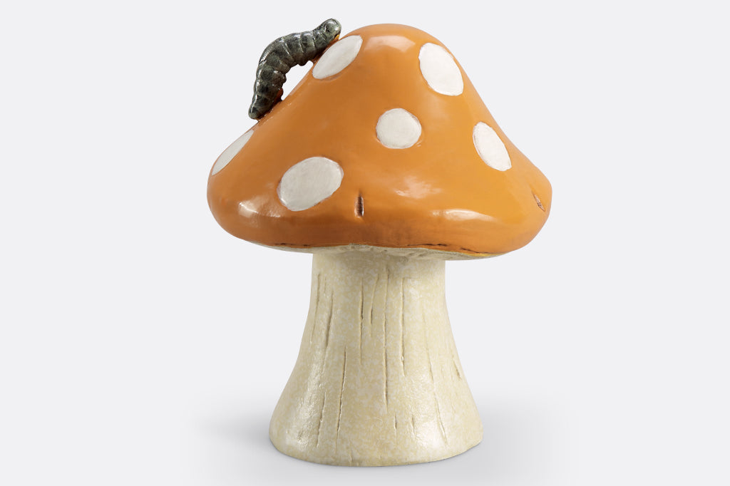 dark mustard colored mushroom garden sculpture with caterpillar on mushroom cap