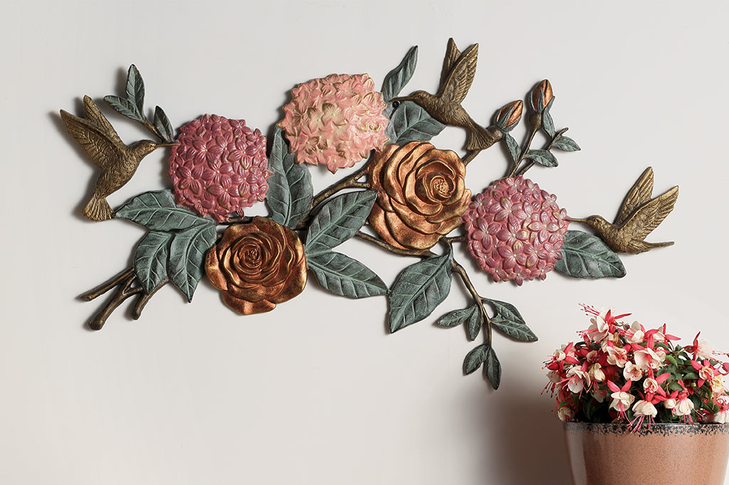 cast metal roses, hydrangeas and hummingbirds wall plaque. Fluttering hummingbirds arounds pink roses