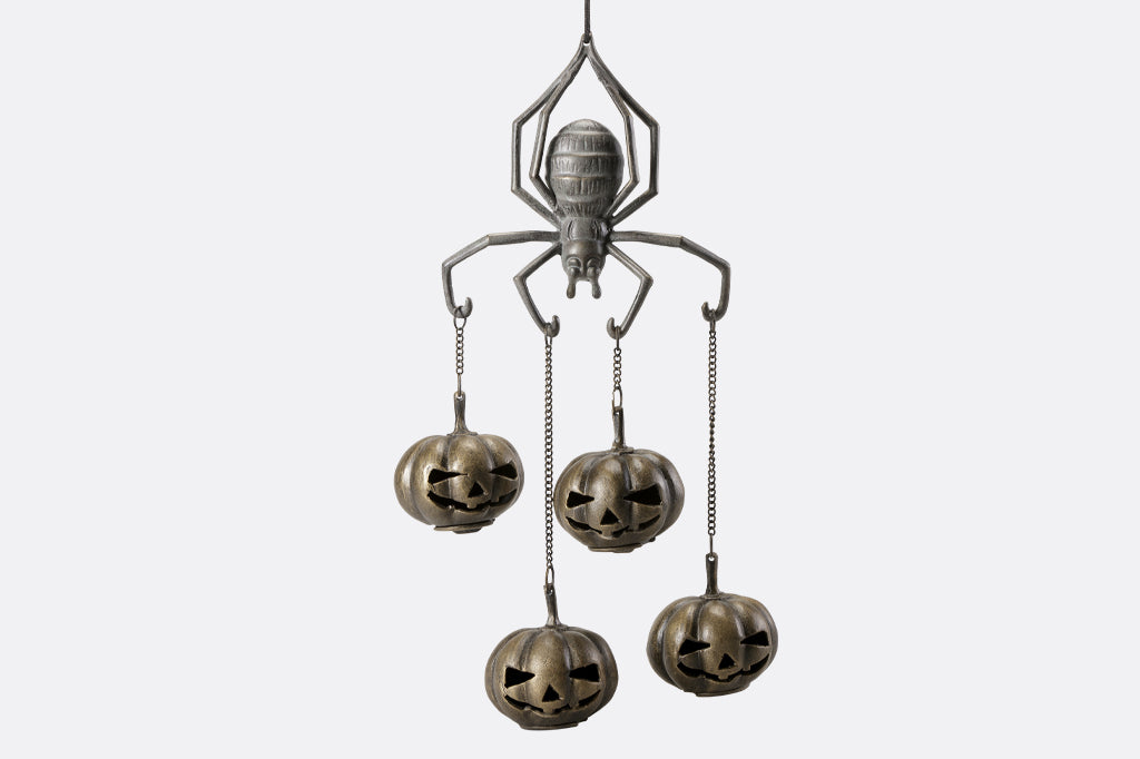 cast metal spider with four jack o lantern pumpkins suspended from spider arms