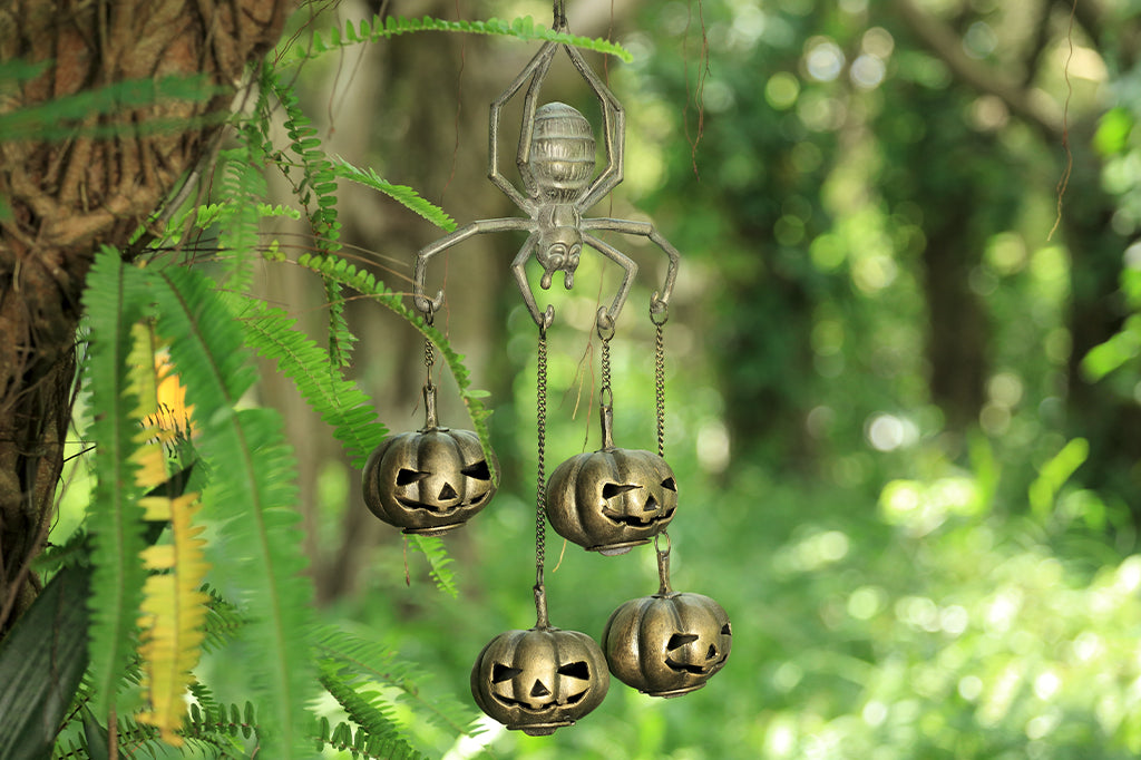 cast metal spider with four jack o lantern pumpkins suspended from spider arms
