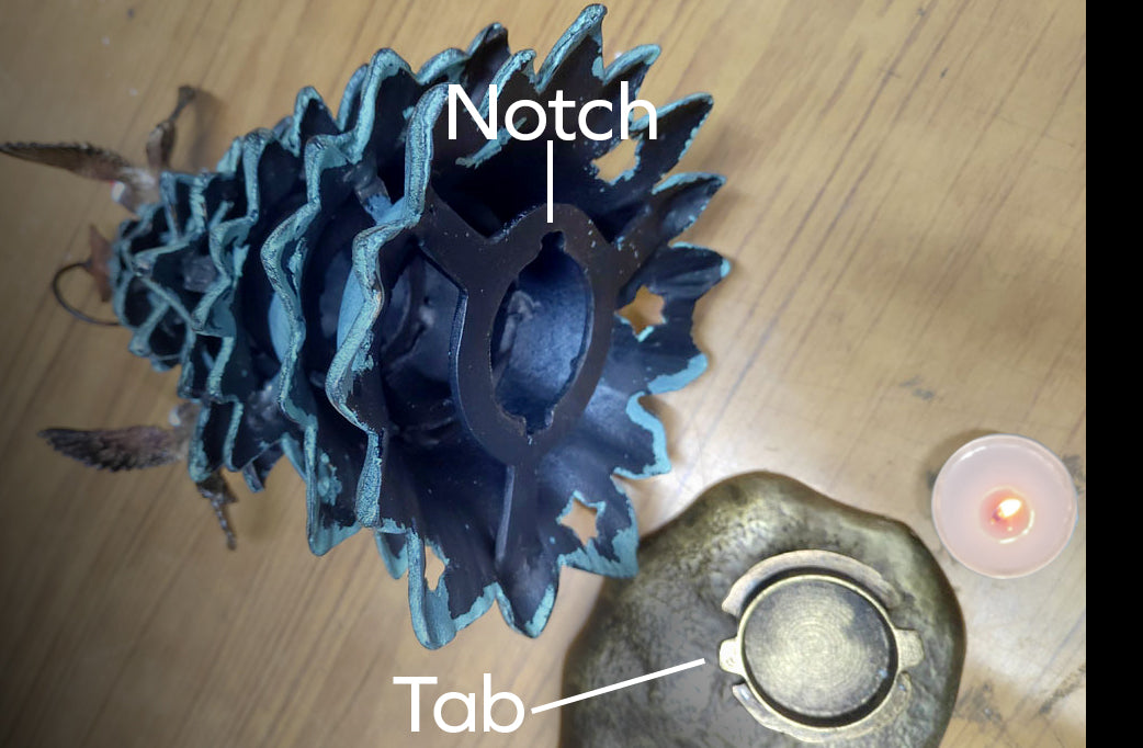 metal tree candle holder shown with the twisting mechanism to fasten cover