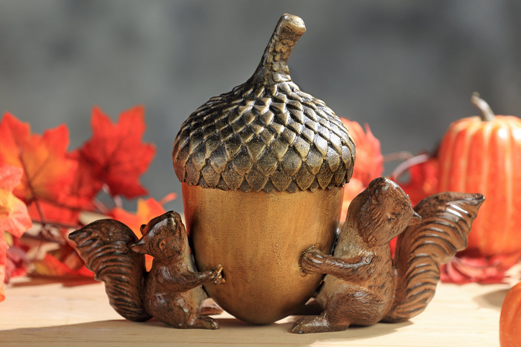 cast metal squirrels holding a acorn set on counter