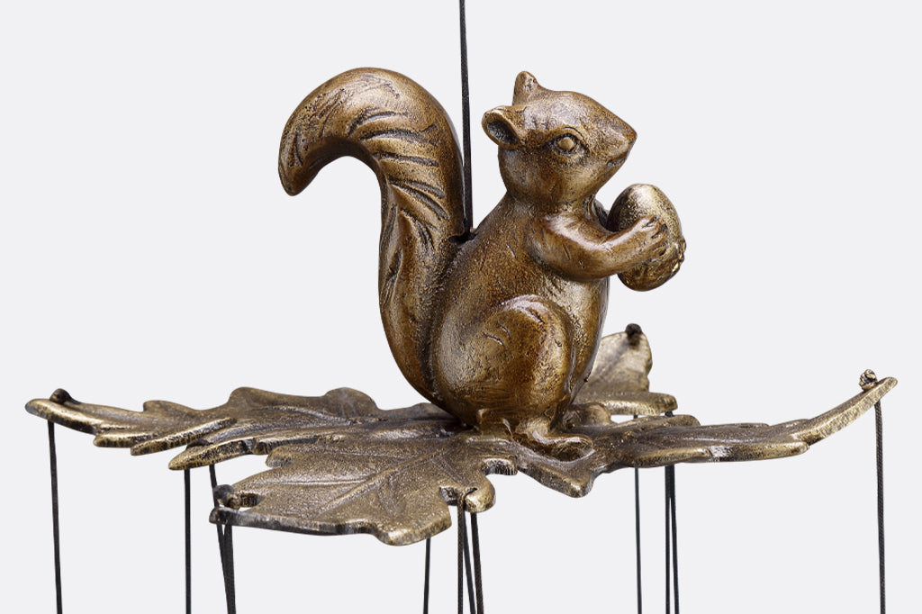 close up of squirrel holding acorn on set of leaves