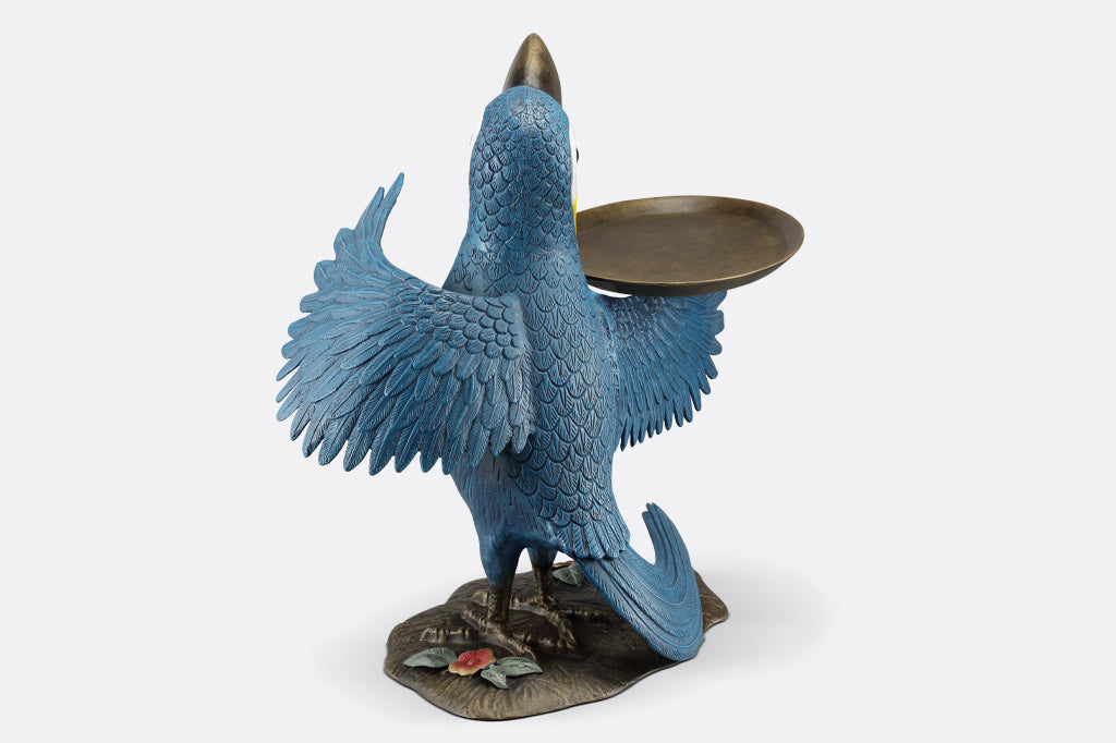 cast metal toucan holding a serving tray on wing, blue and yellow toucan
