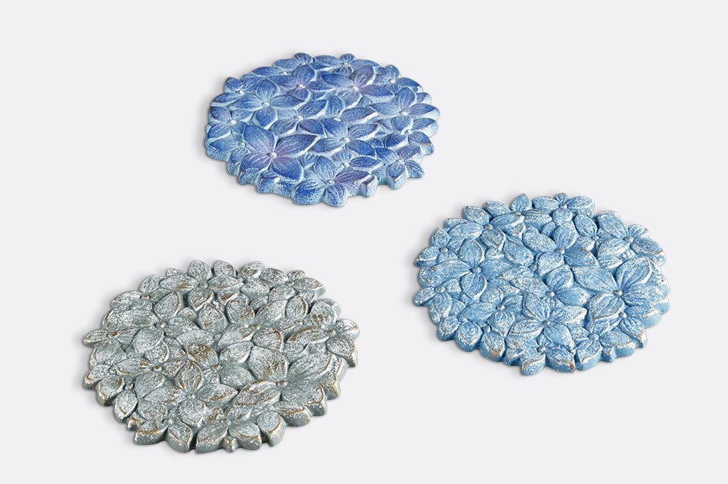3 coasters of blue hydrangea blossoms shown at angle- 3 hues