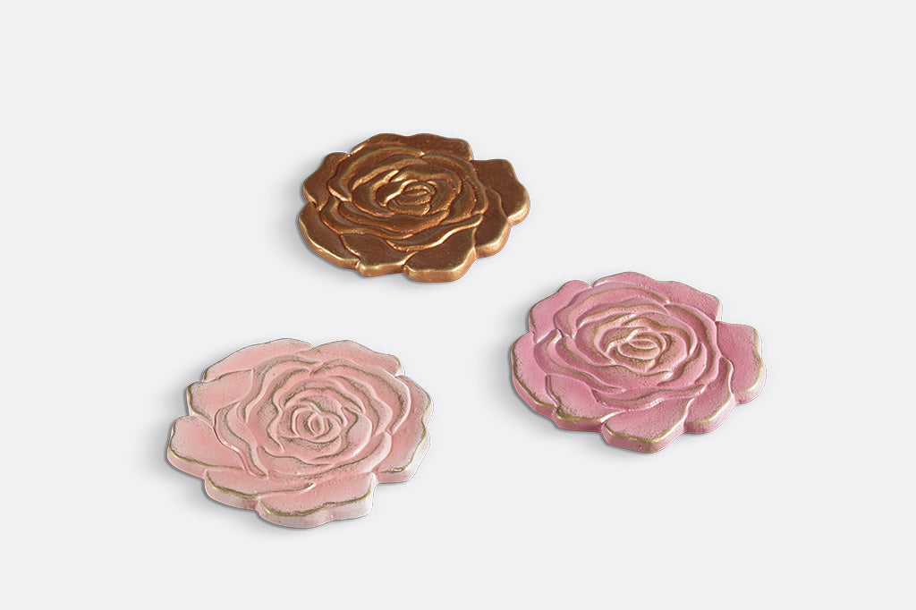 Three rose blossom coasters in shades of pink and copper