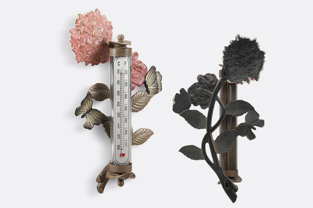 Side and back view: Wall mounted thermometer with cast metal accents of pink rose and hydrangea blossoms, butterflies, and leaves