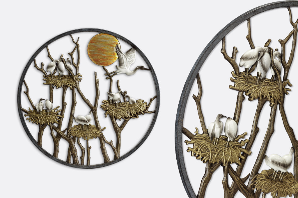 Cast metal wall plaque displaying herons nesting among the branches under the sun
