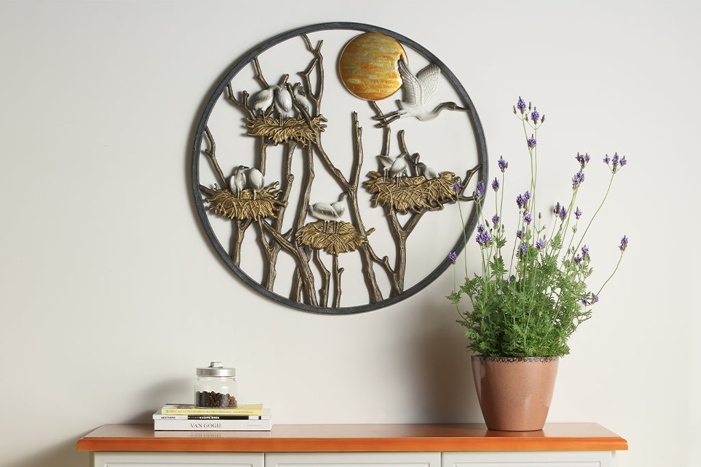 Cast metal wall plaque displaying herons nesting among the branches under the sun