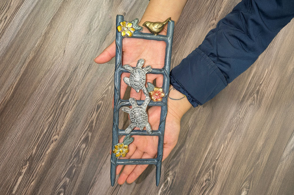 Woman's hands holding the Slow but Steady Pot Trellis above a wood floor