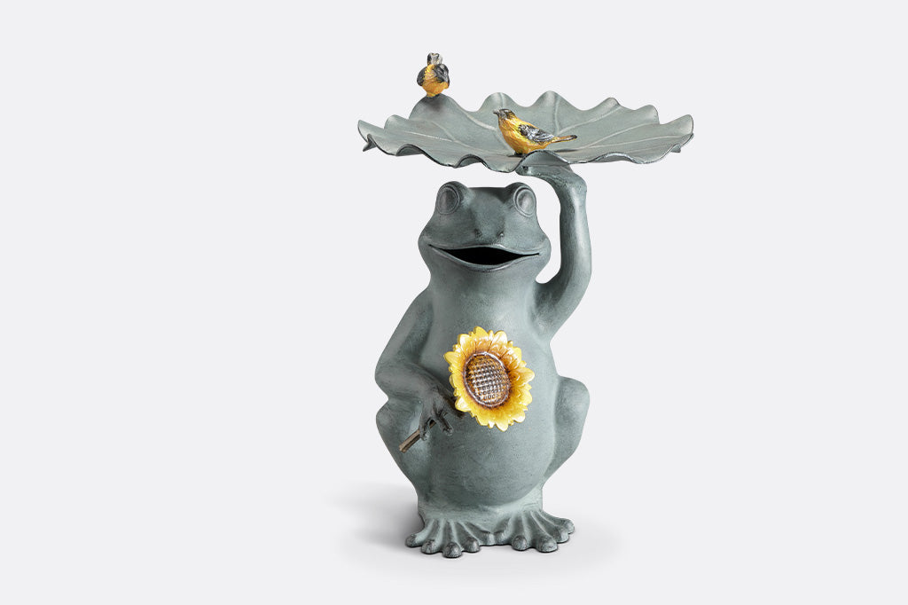 Birdbath that features a Frog holding a sunflower with yellow songbird accents on a lilypad basin.