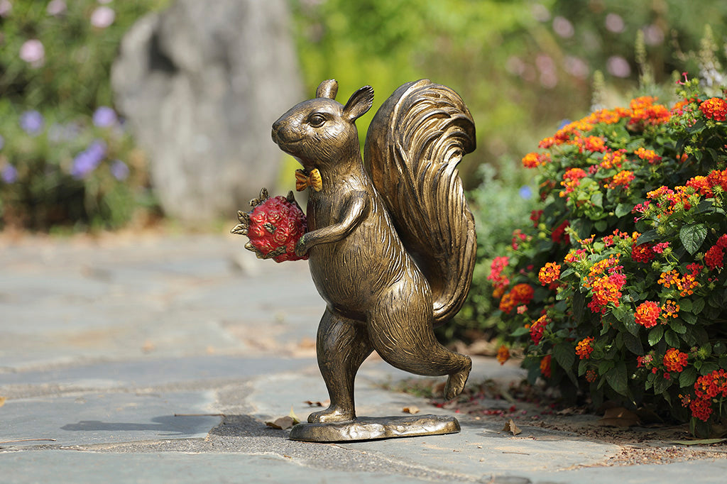 Garden sculpture of squirrel wearing bowtie, running with bouquet of red roses in its paw.