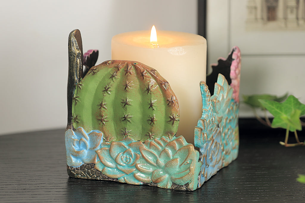 cast metal succulent and cacti candleholder set with candle on table
