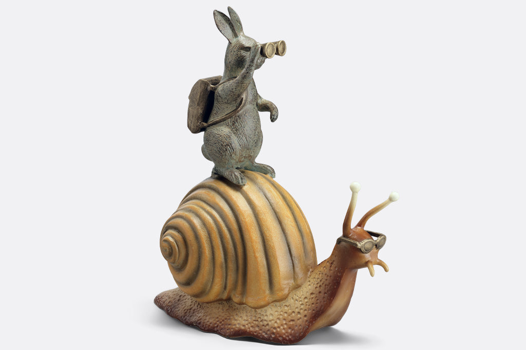 cast metal garden sculpture adventuring rabbit with binoculars riding on a snail with sunglasses