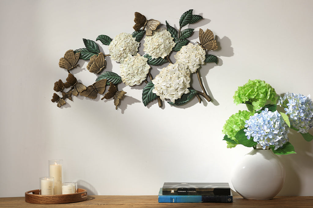 white hydrangea with bronze butterflies fluttering cast metal wall sculpture set above a table console