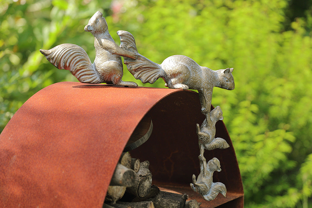 A sculpture of 4 squirrels lifting themselves up a corner.
