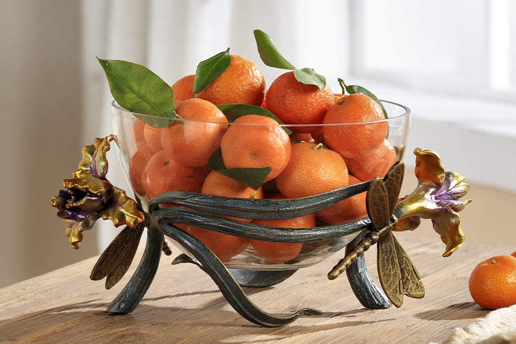 cast aluminum and glass decorative bowl with purple and yellow irises with dragonflies. Filled with tangerines