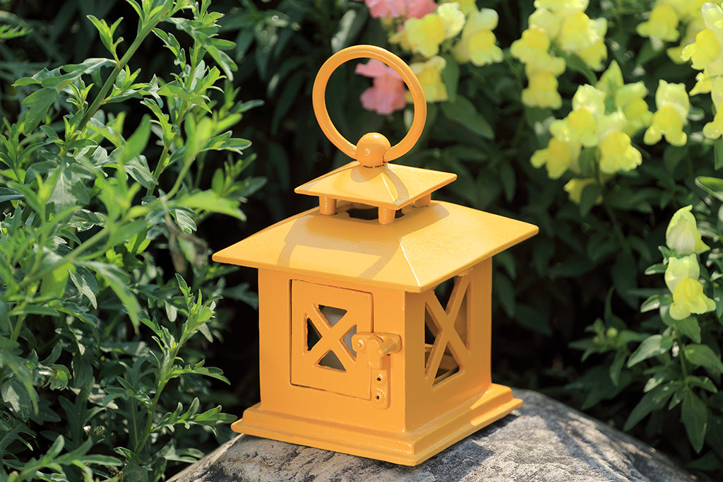 yellow lantern placed on rock in garden #color_yellow
