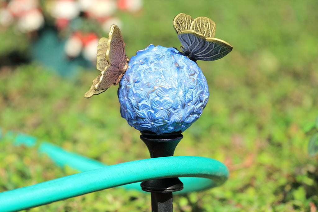 Cast metal blue hydrangea with two butterflies landing on the bloom hose guard