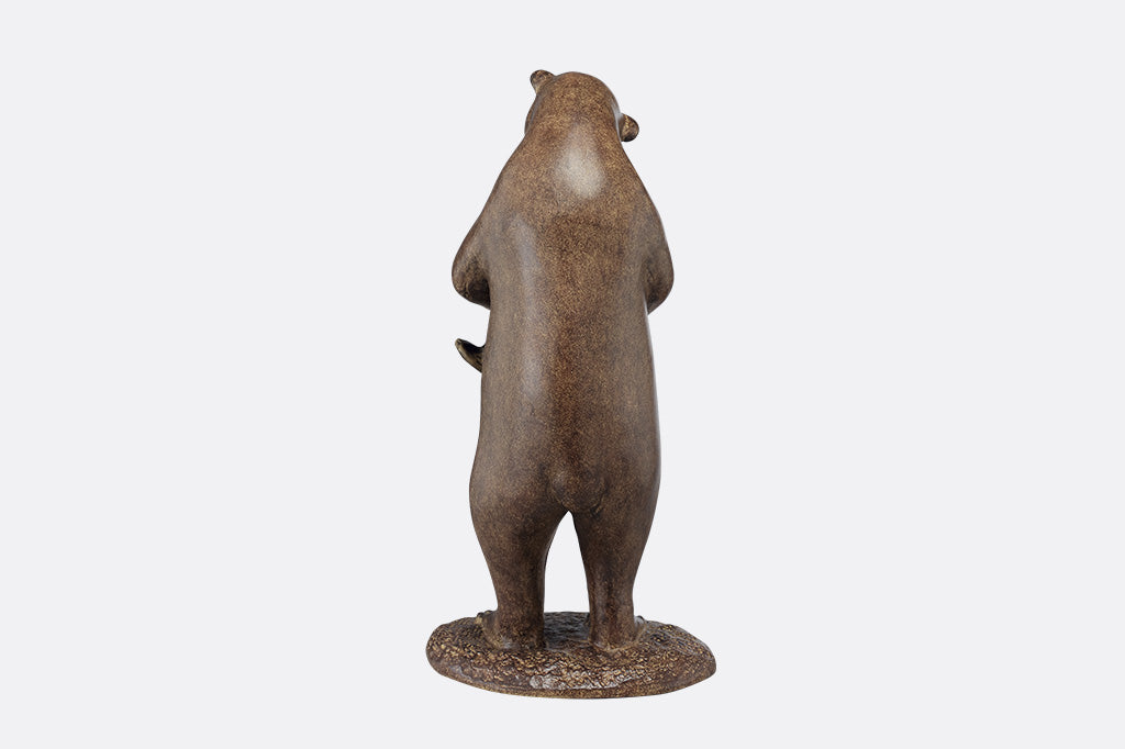 The back of a brown sculpture of a bear holding her cub to hug them.