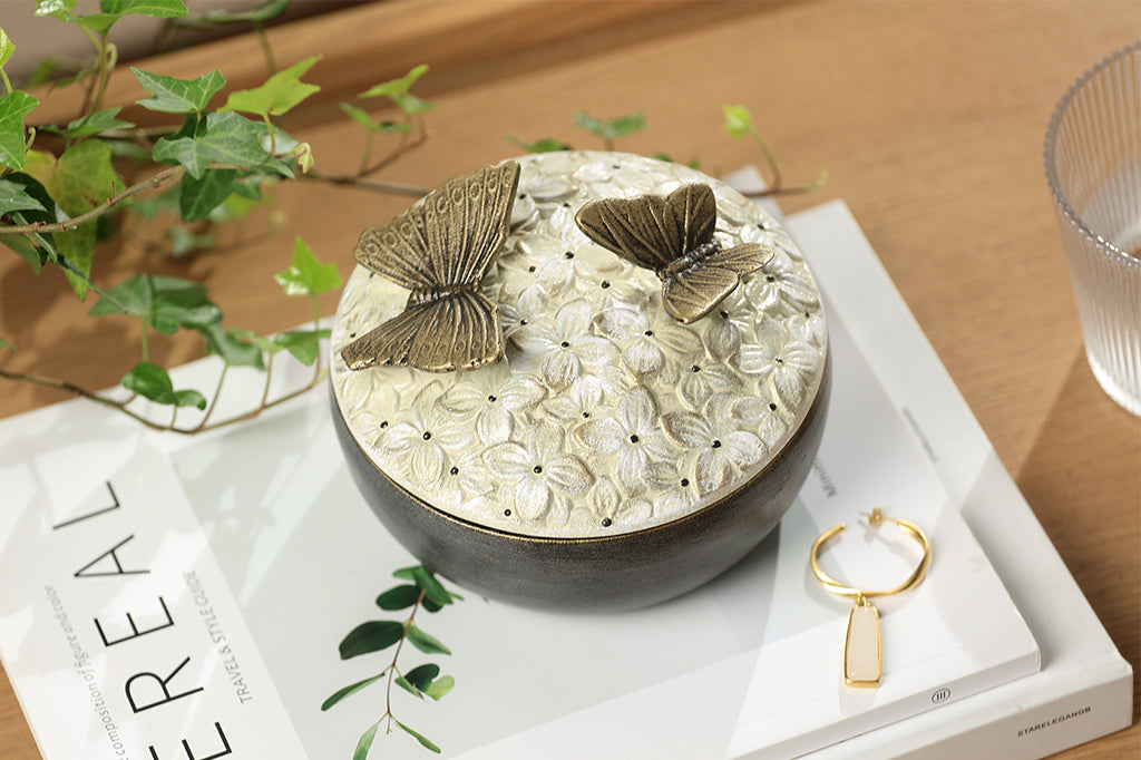 hydrangea box with floral pattern on lid and two bronze butterflies on top