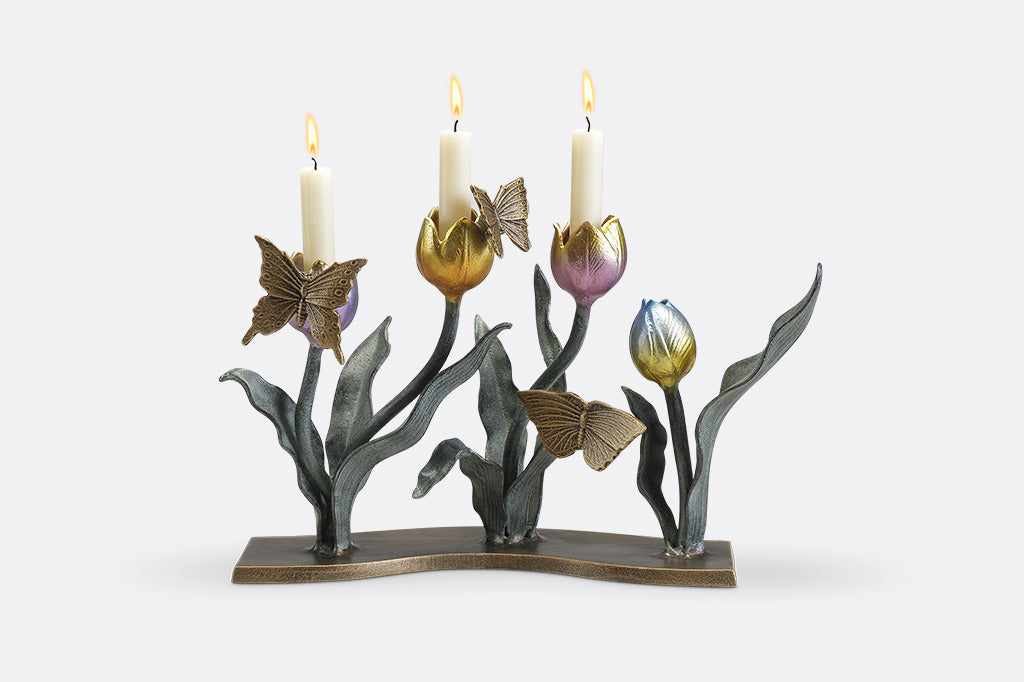 A candleholder sculpture of 4 gold, red, pink, and blue colored tulips with golden butterflies.