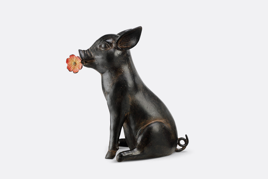 Pig sculpture with a flower in its mouth