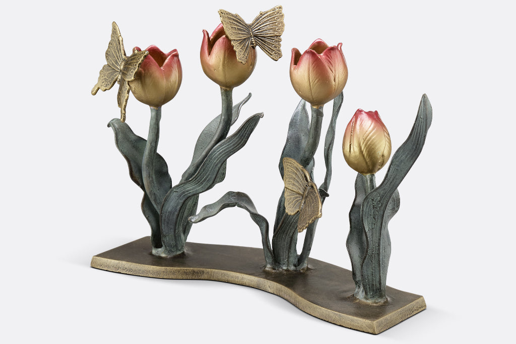 cast metal tulip taper candleholder, tulips are a gradient of pink to yellow. group of three butterflies on petals and foliage
