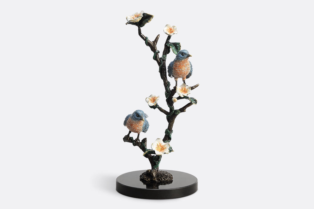 Decorative figurine of birds on a branch with flowers on a white background