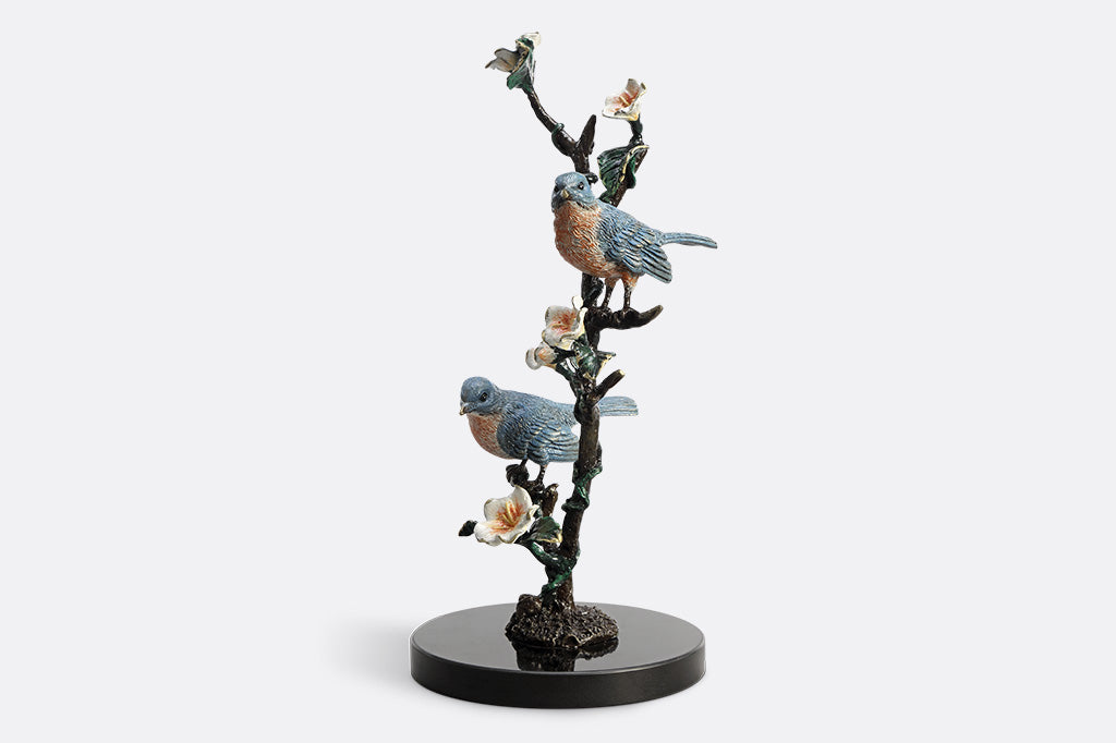Decorative figurine of birds on a branch with flowers on a white background