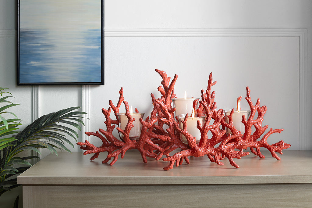 A candleholder in the shape of a pink coral reef that holds votive candles.