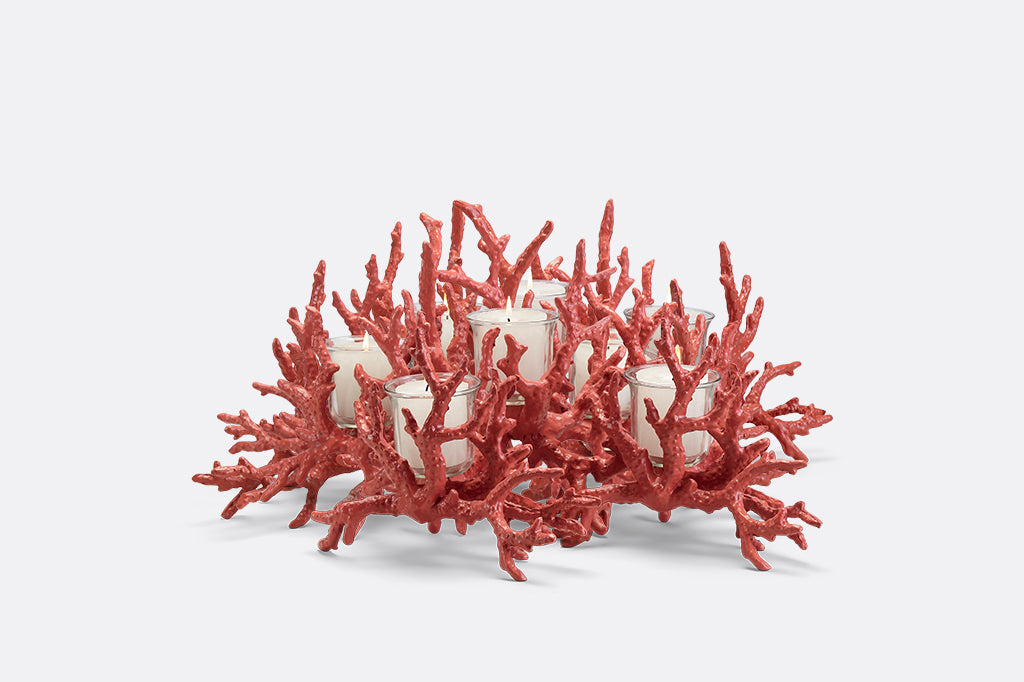 A candleholder in the shape of a pink coral reef that holds votive candles.