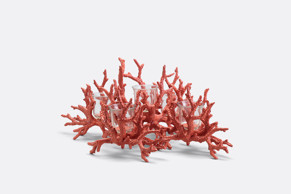 A candleholder in the shape of a pink coral reef that holds votive candles.