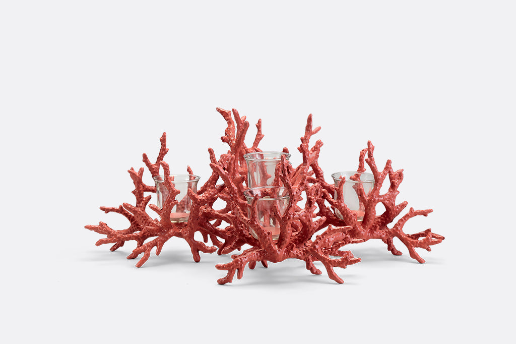 A candleholder in the shape of a pink coral reef that holds votive candles.