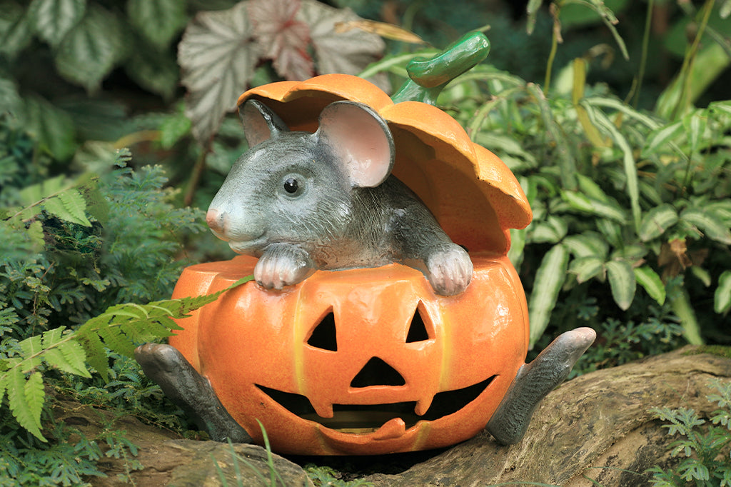 Cast metal gray mouse in jack o lantern set in garden scene