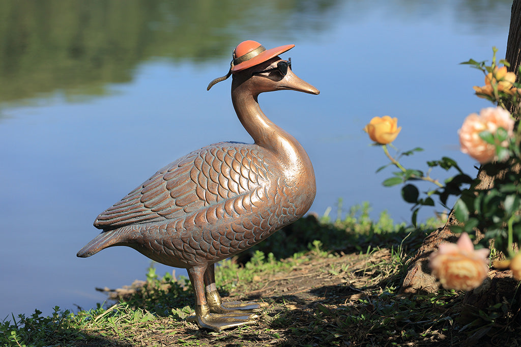 A sculpture of a duck wearing sunglasses and a sunhat.